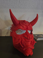 Oni-Maske Der Dämon in Rot, Ansicht leicht von der Seite mit sichtbaren Reißzähnen vor weißer Wand – Münch3D