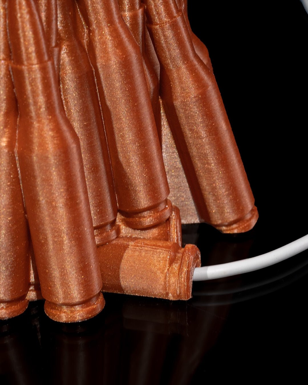 Kupferfarbener Patronen-Handyhalter, Nahaufnahme der Patronenböden mit herausgeführtem Ladekabel