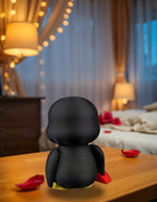 Einzelne Pinguin-Figur mit Herzschloss-Hälfte auf Nachttisch mit Rosenblättern, Rückansicht mit gelben Füßen – Münch3D