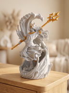 Poseidon-Statue Marmor-Optik mit Gold: Figur mit Dreizack in erhobener Hand, umgeben von marmorner Wellenform, auf Nachttisch mit getrockneten Blumen im Hintergrund