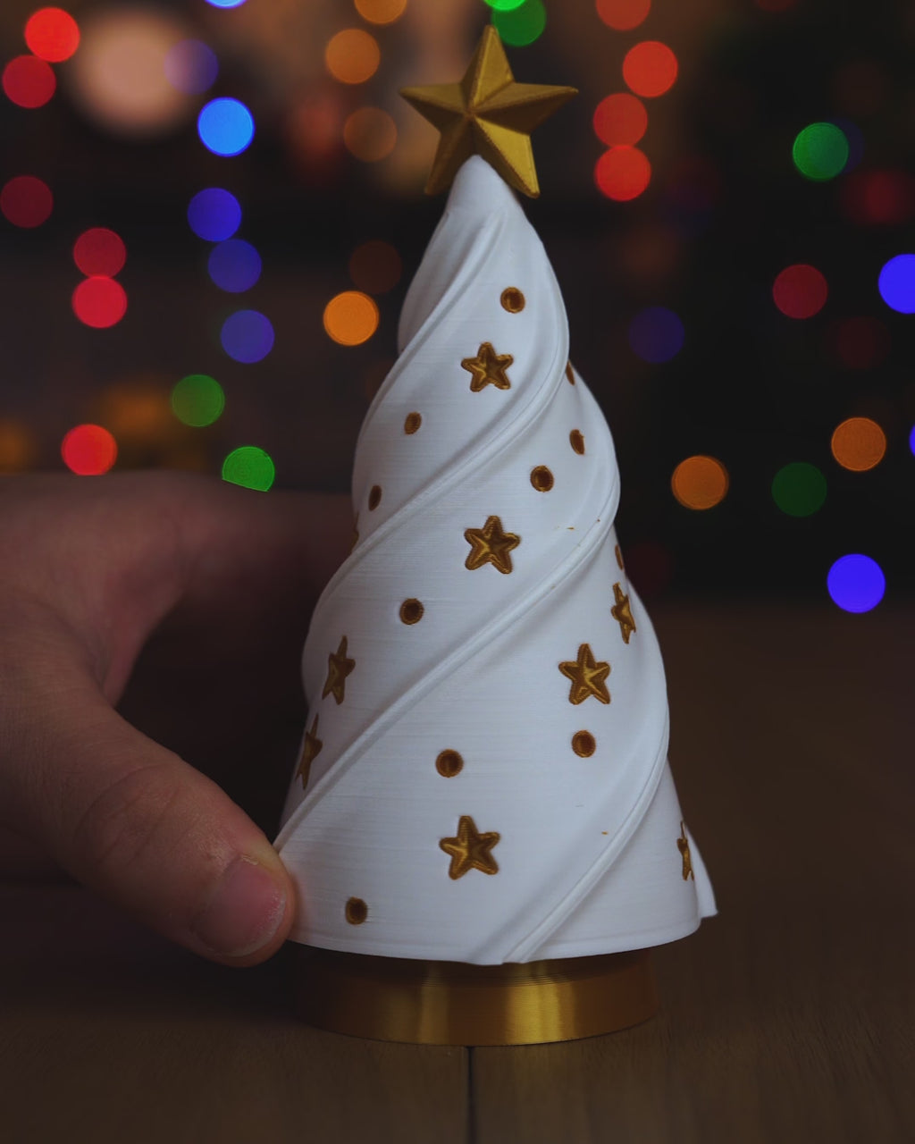 Kurzvideo: Der weiße Weihnachtsbaum wird vom goldenen Sockel mit LED-Teelicht abgehoben und wieder aufgesetzt, das warme Licht scheint durch Baum und Sterne