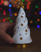 Kurzvideo: Der weiße Weihnachtsbaum wird vom goldenen Sockel mit LED-Teelicht abgehoben und wieder aufgesetzt, das warme Licht scheint durch Baum und Sterne