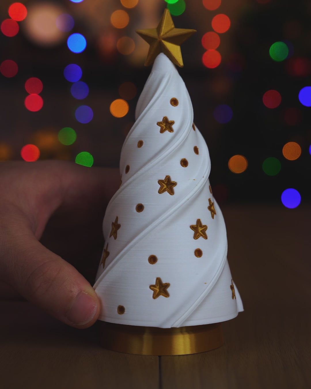 Kurzvideo: Der weiße Weihnachtsbaum wird vom goldenen Sockel mit LED-Teelicht abgehoben und wieder aufgesetzt, das warme Licht scheint durch Baum und Sterne