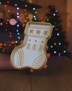 Kurzvideo: Weiß-goldene Nikolausstiefel-Schale wird in der Hand gedreht, im Hintergrund leuchten Weihnachtsbaum-Lichter