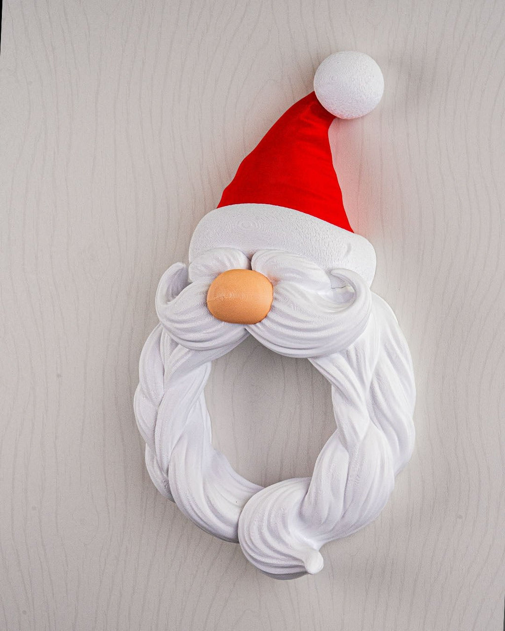Weihnachtsmann Türkranz Santa's Welcome, Frontalansicht mit Bartsträhnen und Knollennase vor heller Holzoptik-Wand – Münch3D
