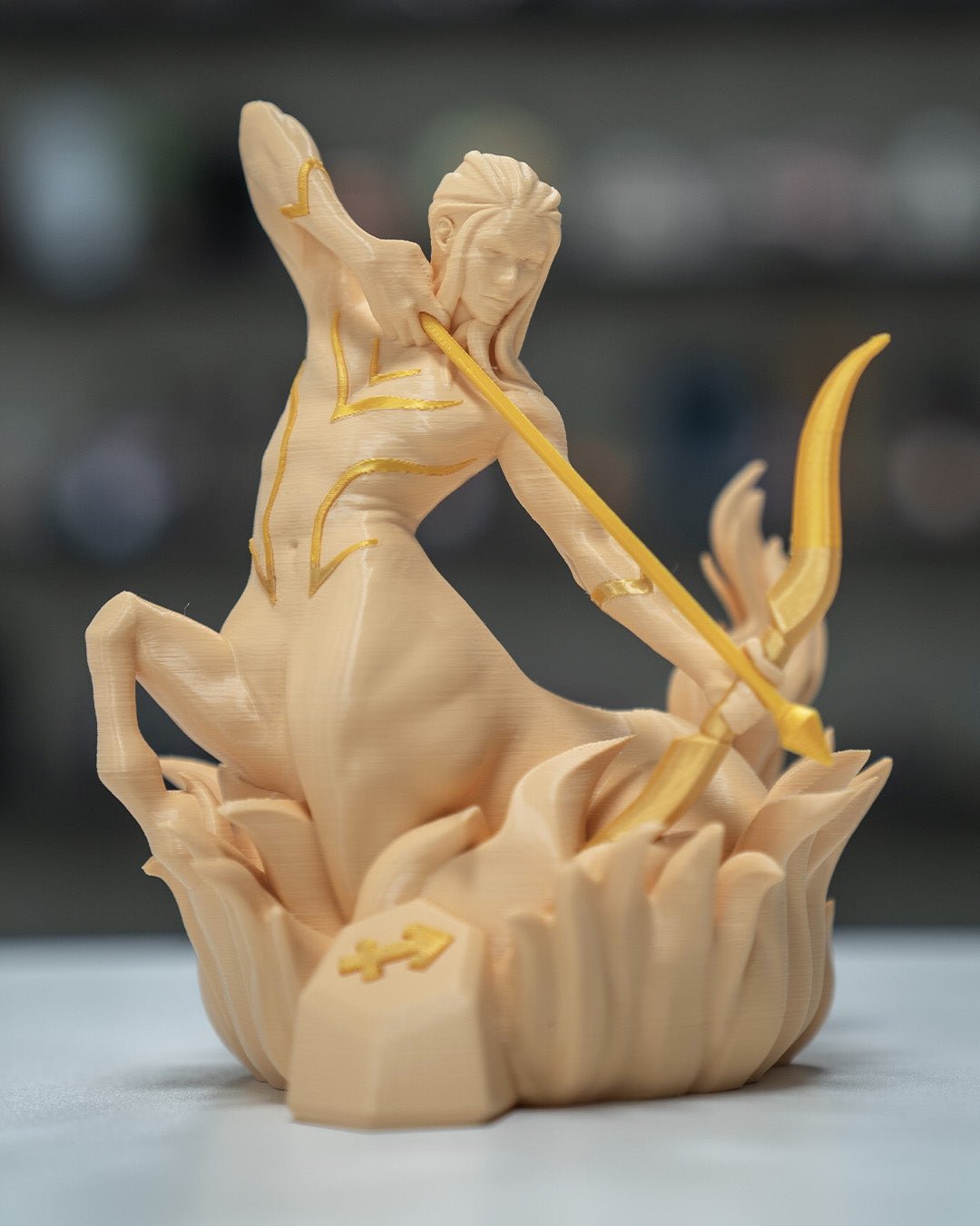 Schütze-Sternzeichen-Skulptur (Zentaur) in Creme mit goldenen Akzenten im Regal, unscharfer Hintergrund