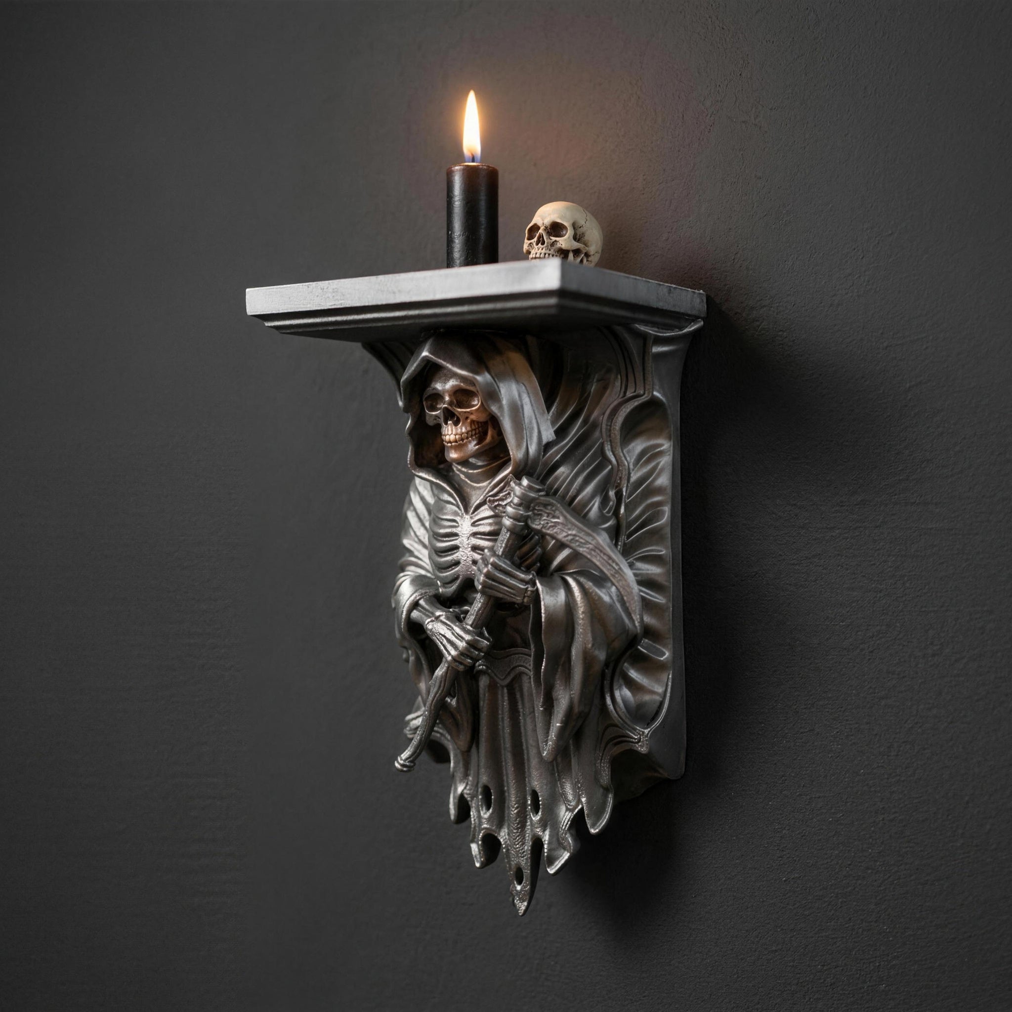 Silver Grim Reaper wall shelf styled with a burning candle and decorative skull on top
