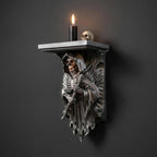 Silver Grim Reaper wall shelf styled with a burning candle and decorative skull on top