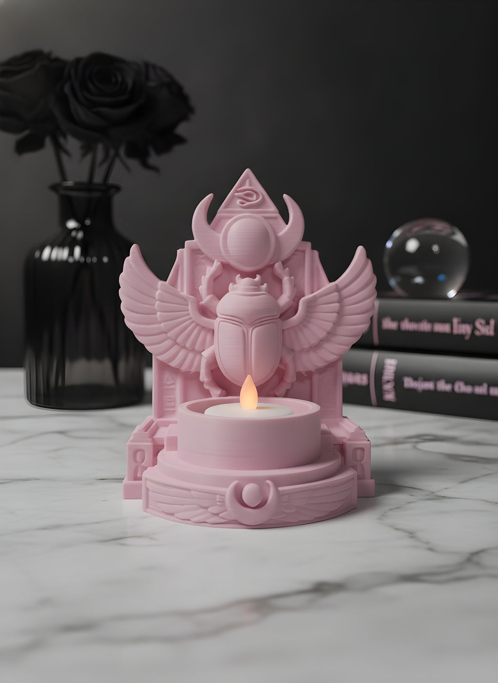 Rosa Skarabäus-Teelichthalter auf Marmortisch neben schwarzer Vase mit getrockneten Rosen und Kristallkugel, LED-Teelicht leuchtet