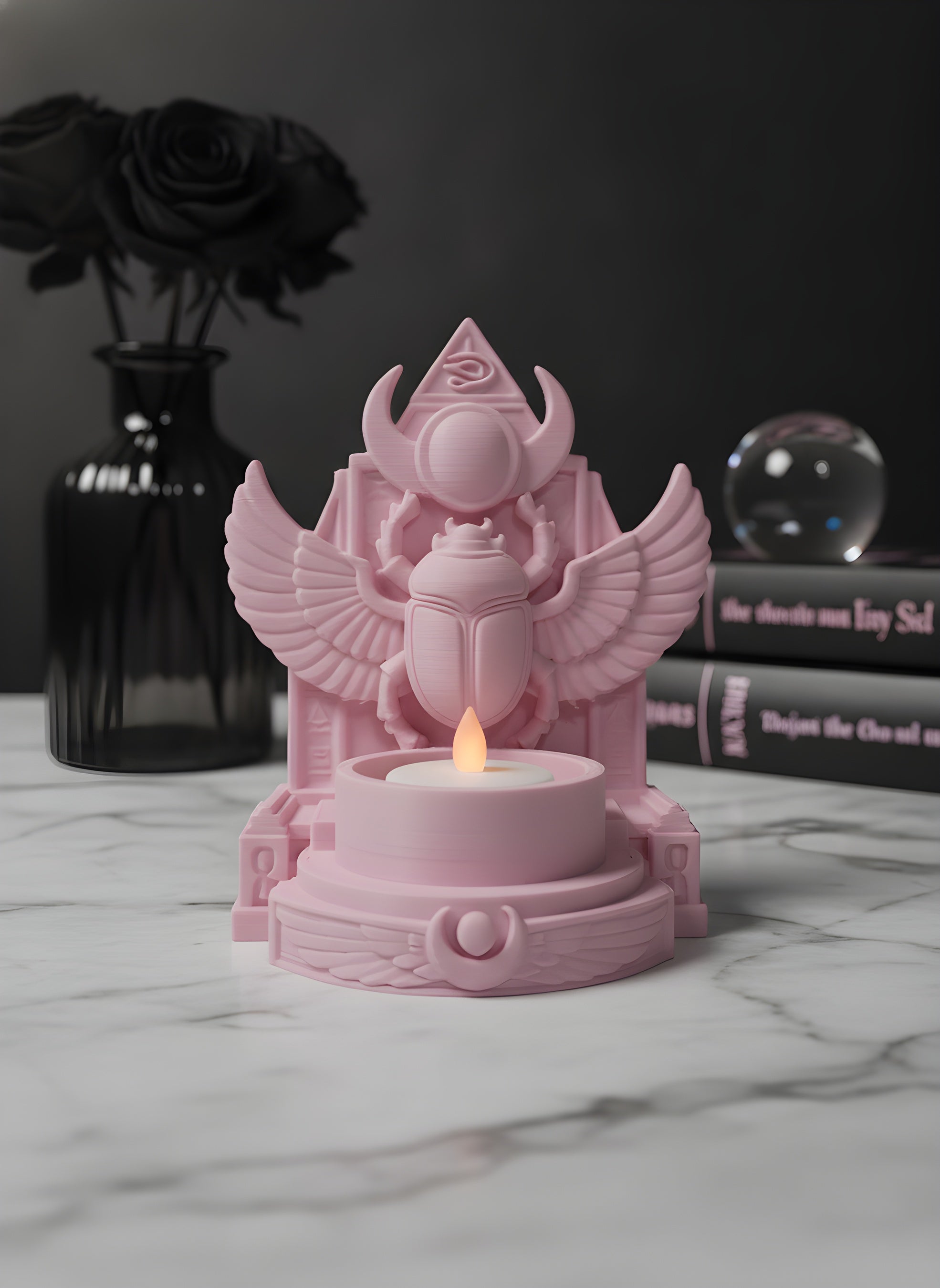 Rosa Skarabäus-Teelichthalter auf Marmortisch neben schwarzer Vase mit getrockneten Rosen und Kristallkugel, LED-Teelicht leuchtet