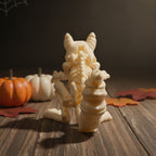 Skelett-Eichhörnchen-Figur von hinten, Wirbelsäule und geringelter Schwanz sichtbar, mit orangefarbenem und weißem Mini-Kürbis im Hintergrund