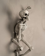 Skelett-Wanddeko 'The Skull' in gealterter Knochenoptik, Seitenprofil aus anderem Blickwinkel an heller Wand montiert