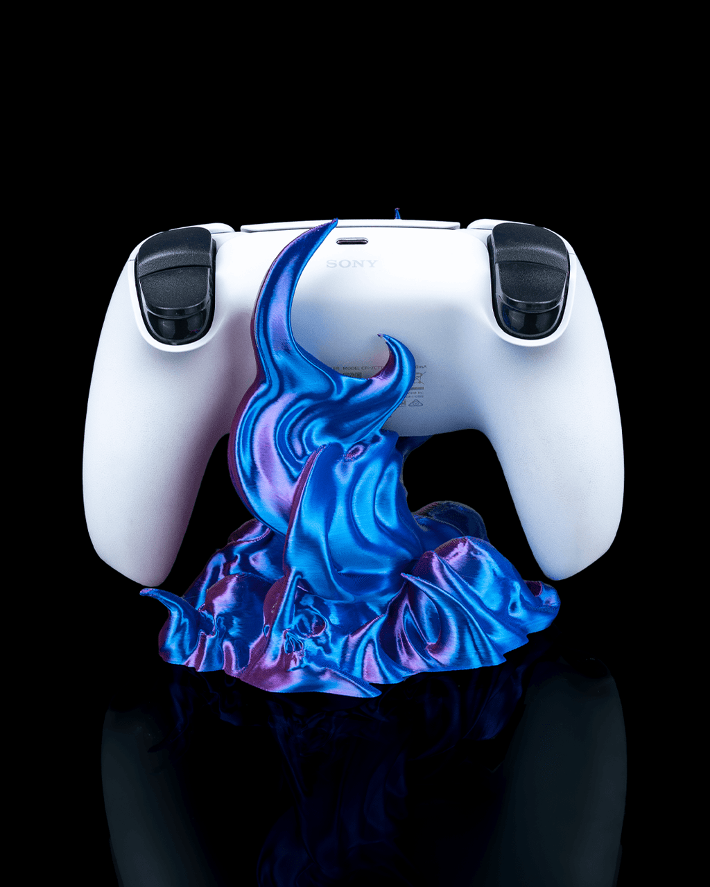 Weißer Gaming-Controller von hinten auf dem Skullflame-Sockel, blau-lila Flammen-Design mit Totenkopf-Reliefs, freigestellt vor schwarzem Hintergrund.
