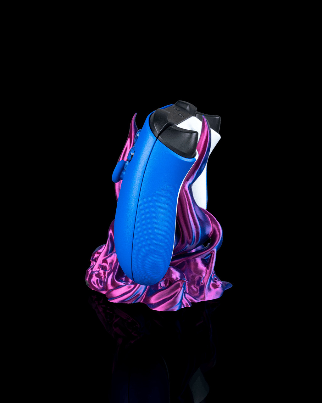 Skullflame Controller-Halter von der Seite mit zwei Controllern gleichzeitig, blauer Controller vorne und weißer Controller dahinter sichtbar, auf demselben pink-lila-blauen Sockel.