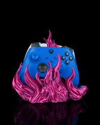 Skullflame Dual Controller-Halter in Pink, Frontalansicht freigestellt vor schwarzem Hintergrund, überwiegend blauer Gaming-Controller sichtbar, weißer Controller nur angeschnitten am oberen Rand.
