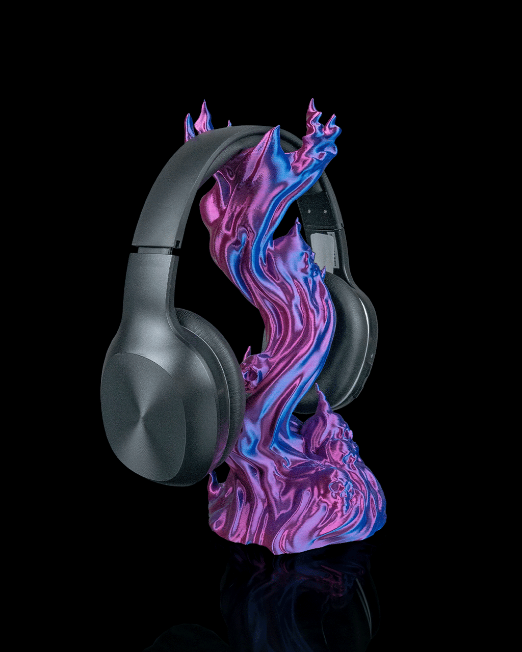 Skullflame Headset-Halter in Blau-Lila, Ansicht schräg von der Seite mit aufgehängtem Over-Ear-Kopfhörer, mehrere Totenkopf-Reliefs im unteren Sockel sichtbar, freigestellt vor schwarzem Hintergrund.