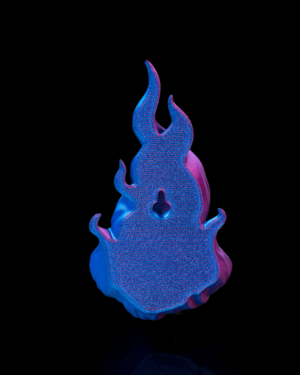 Skullflame Wand-Halter von hinten, strukturierte Rückseite mit mittigem Schlüsselloch-Montageloch, Blau-Pink, freigestellt vor schwarzem Hintergrund.