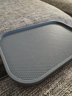 Leeres dunkelgraues Sofatablett, Detailaufnahme der geriffelten Oberfläche auf Couch-Armlehne, kein Buch oder Brille im Bild
