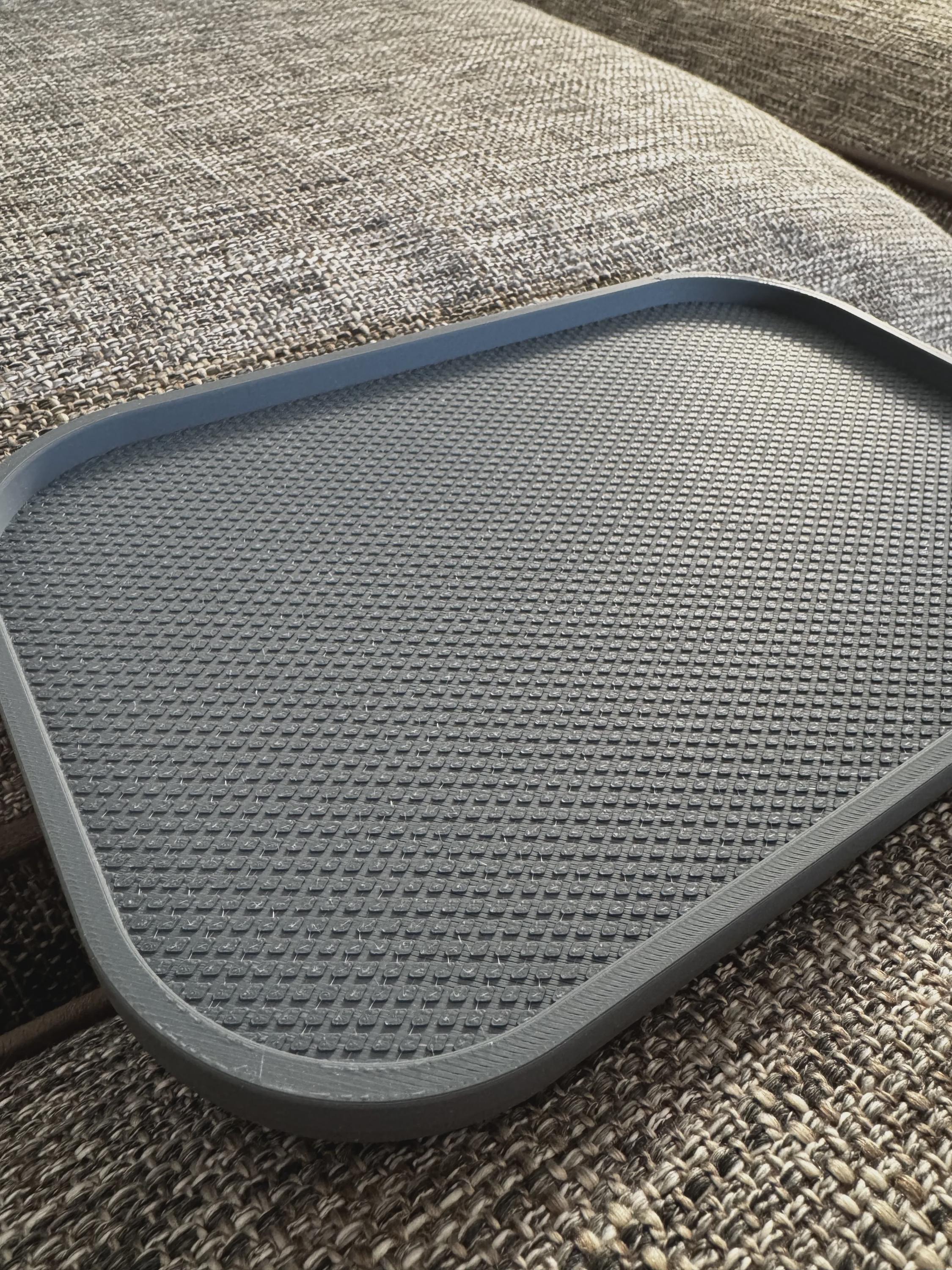 Leeres dunkelgraues Sofatablett, Detailaufnahme der geriffelten Oberfläche auf Couch-Armlehne, kein Buch oder Brille im Bild