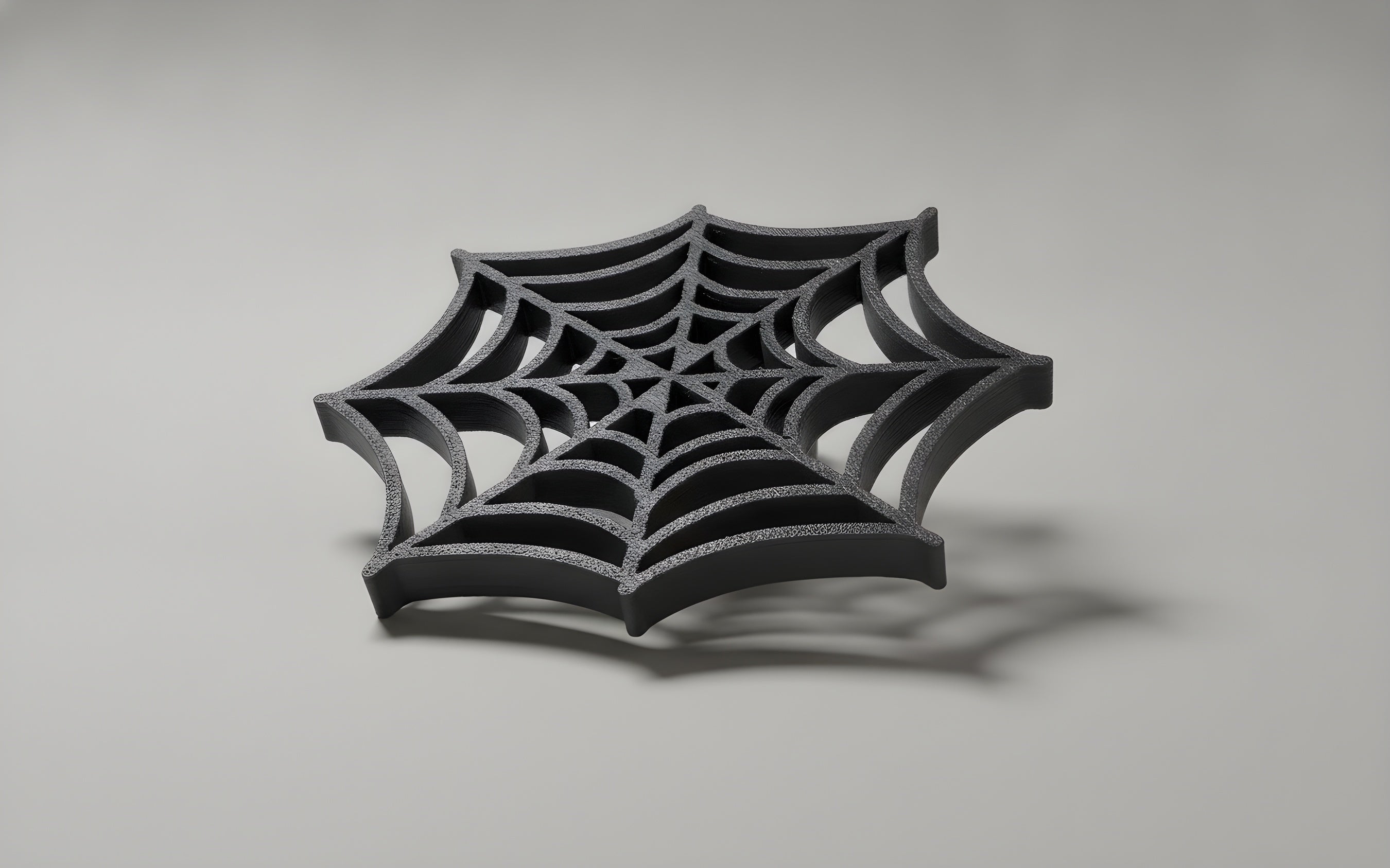 Spinnennetz-Möbelknopf mit filigranem Netzmuster, Studiofoto auf grauem Hintergrund