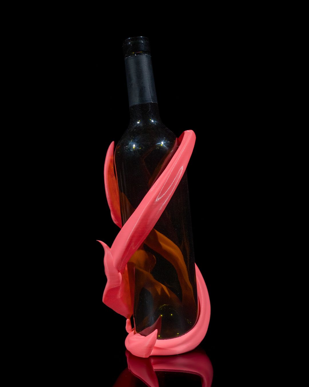 Tänzerin-Weinflaschenhalter in Pink vor schwarzem Hintergrund, Bänder umschlingen die Flasche von vorne – Münch3D