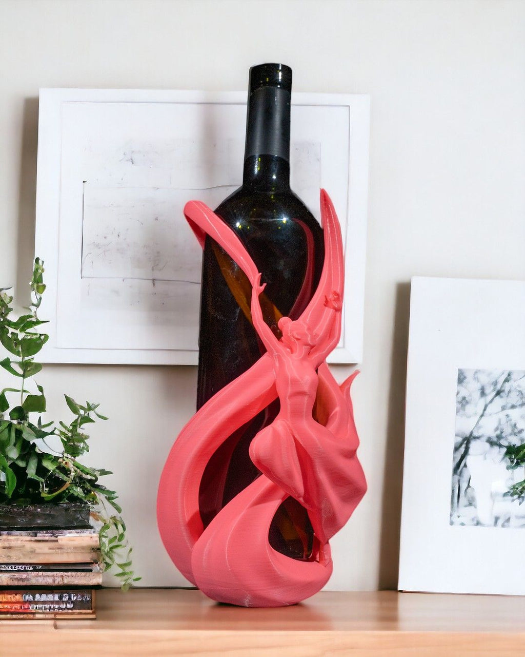 Tänzerin-Weinflaschenhalter in Pink im Wohnzimmer mit Pflanze und Büchern im Hintergrund, Ansicht mit Weinflasche – Münch3D