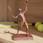 Tennisspieler-Statue in Kupfer-Bronze-Optik auf Holzregal, Seitenansicht der Aufschlagpose, unscharfer Hintergrund mit Tennisschläger und Bällen – Münch3D