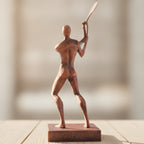 Tennisspieler-Statue in Kupfer-Bronze-Optik, gerade Rückansicht mit erhobenem Schlägerarm auf Holzoberfläche, weich unscharfer warmer Hintergrund – Münch3D