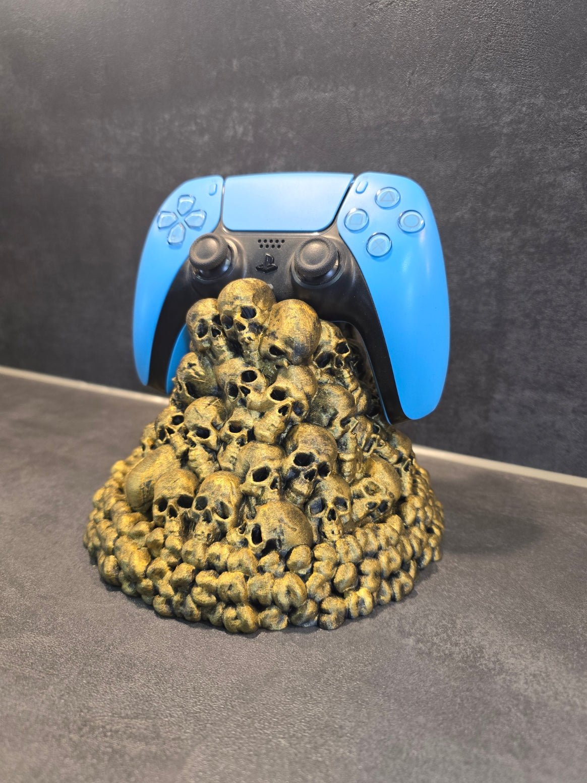Totenkopf-Controllerhalter mit blauem Gaming-Controller, Nahaufnahme der Schädelpyramide – Münch3D