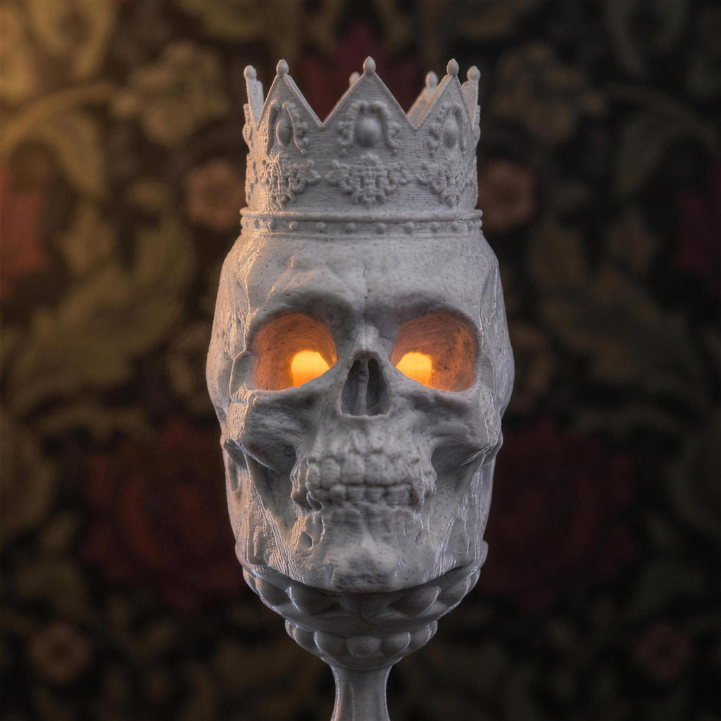 Nahaufnahme des Totenkopf-Kelch-Kerzenhalters mit gotischer Krone und leuchtenden orangefarbenen LED-Augen