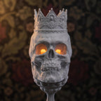 Nahaufnahme des Totenkopf-Kelch-Kerzenhalters mit gotischer Krone und leuchtenden orangefarbenen LED-Augen