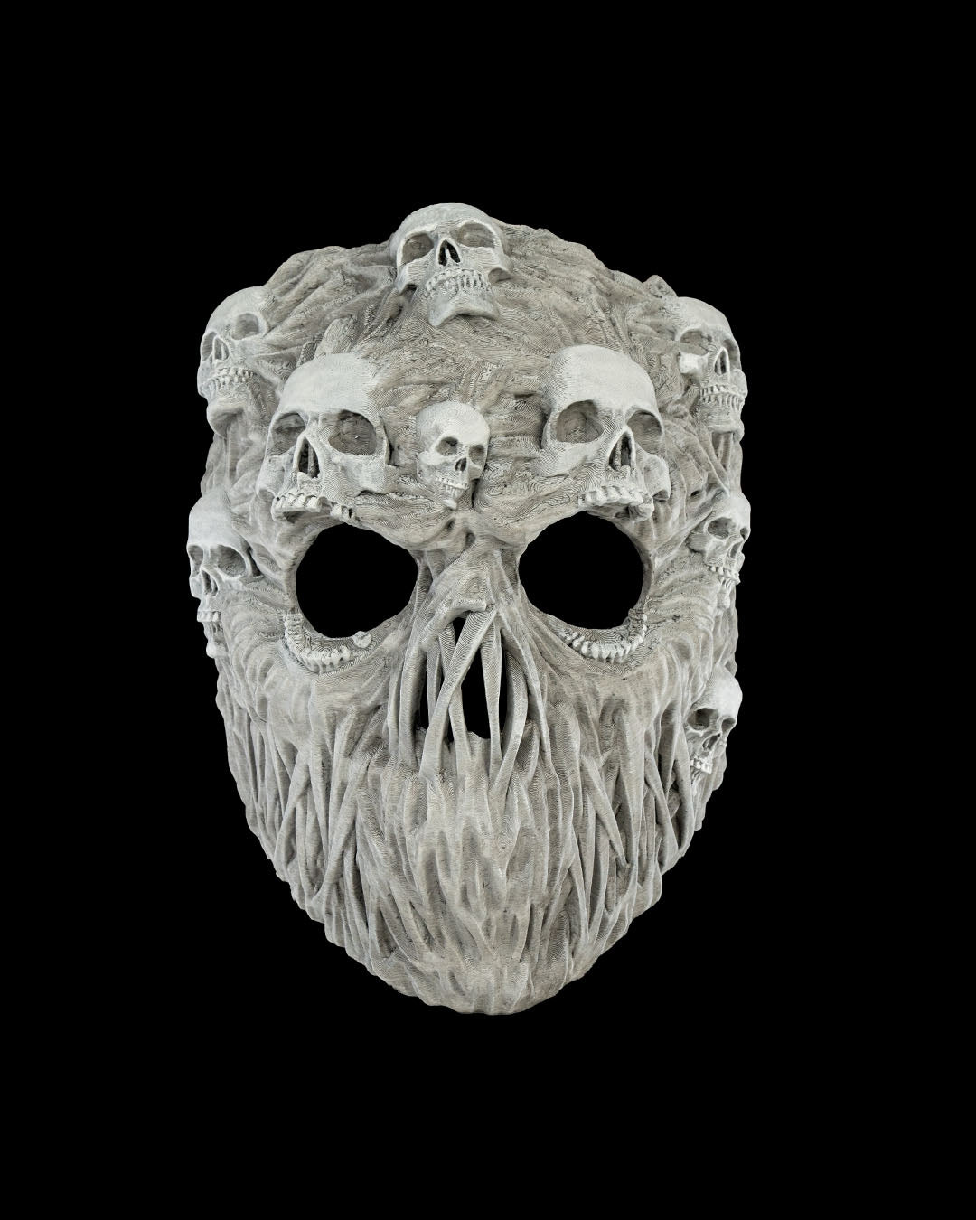 Ghoul-Totenkopf-Maske in Grau mit zahlreichen kleinen Schädeln auf der Oberfläche, Frontalansicht freigestellt vor schwarzem Hintergrund