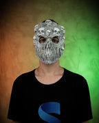 Ghoul-Totenkopf-Maske in Grau getragen von einer Person, Frontalansicht, bunter Farbverlauf-Hintergrund