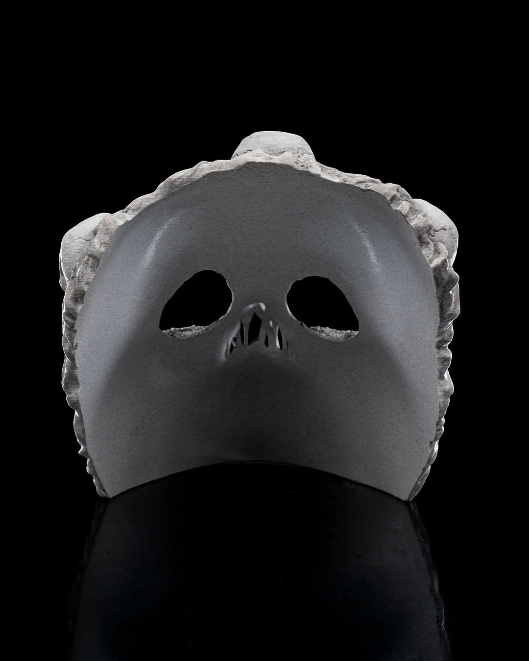 Innenansicht der Ghoul-Totenkopf-Maske: glatte graue Innenseite mit Aussparungen für Augen und Nase, vor schwarzem Hintergrund