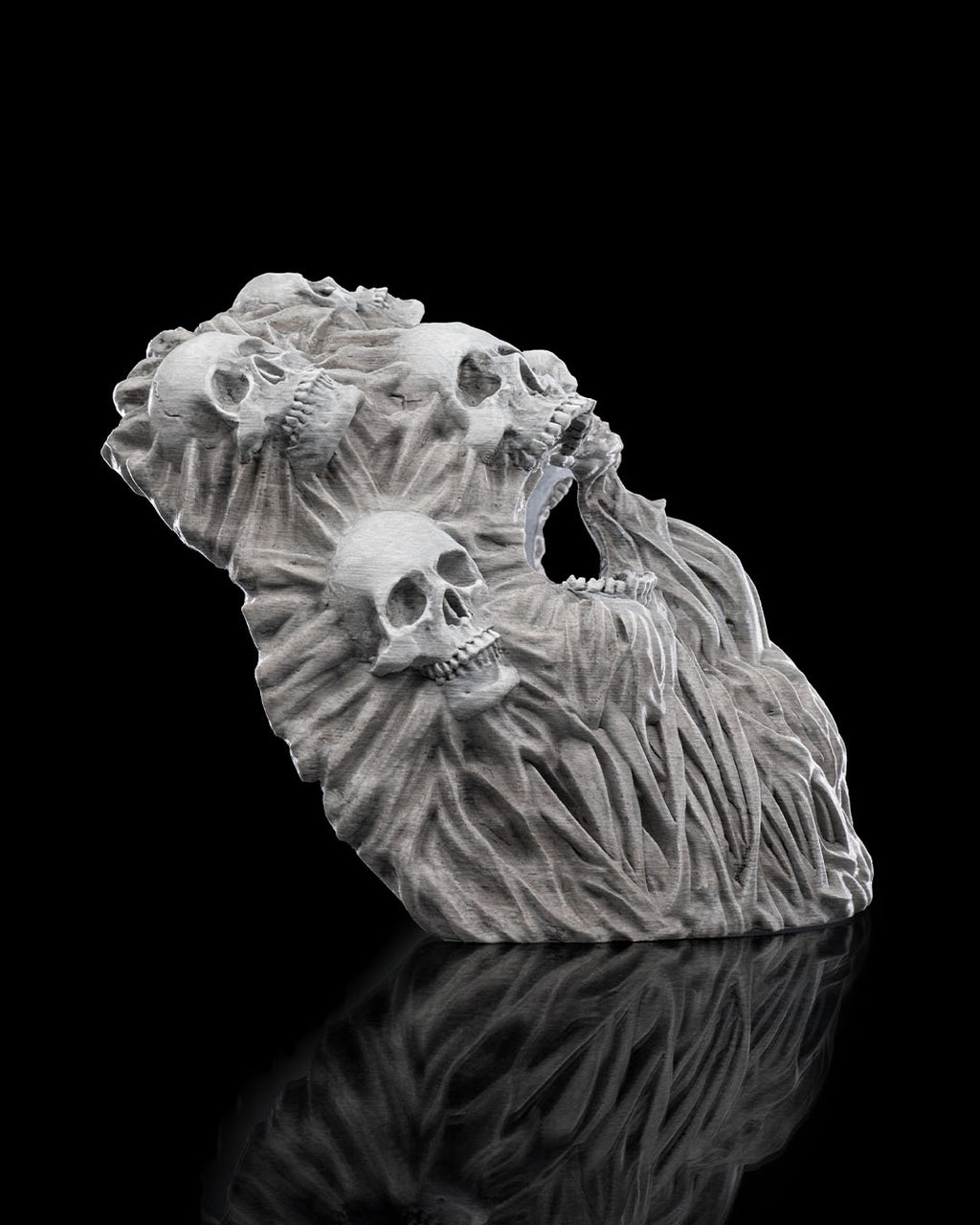 Ghoul-Totenkopf-Maske in Grau, schräg von oben fotografiert mit Blick auf die Schädelverzierungen, vor schwarzem Hintergrund