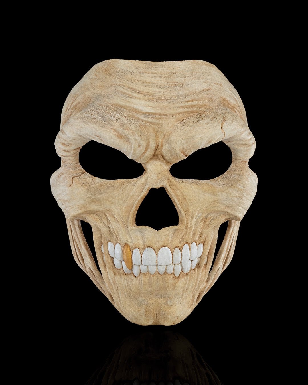 Totenkopf-Halloween-Maske in Creme/Beige mit goldenem Zahn-Akzent, Frontalansicht freigestellt vor schwarzem Hintergrund
