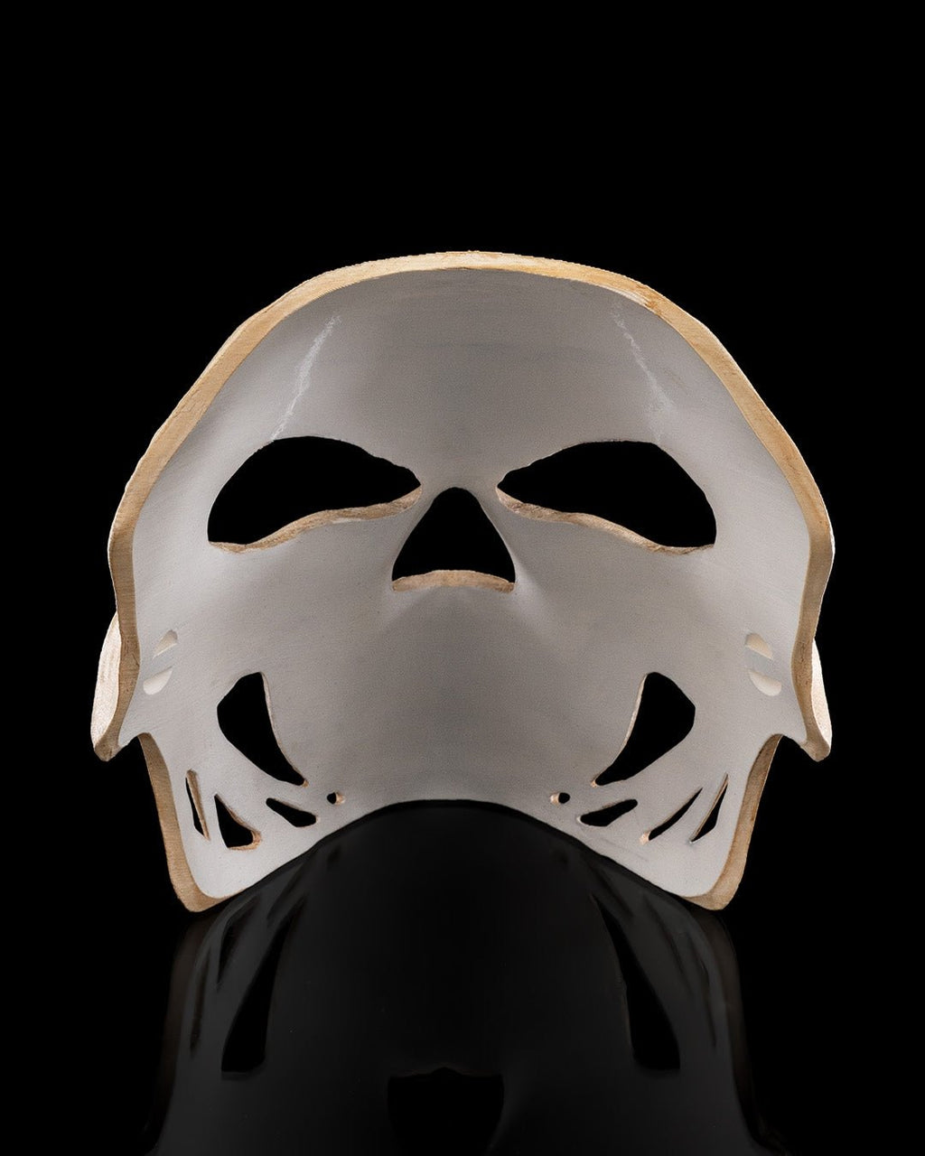 Innenansicht der Totenkopf-Halloween-Maske: Rückseite mit Aussparungen für Augen, Nase und Mund, vor schwarzem Hintergrund