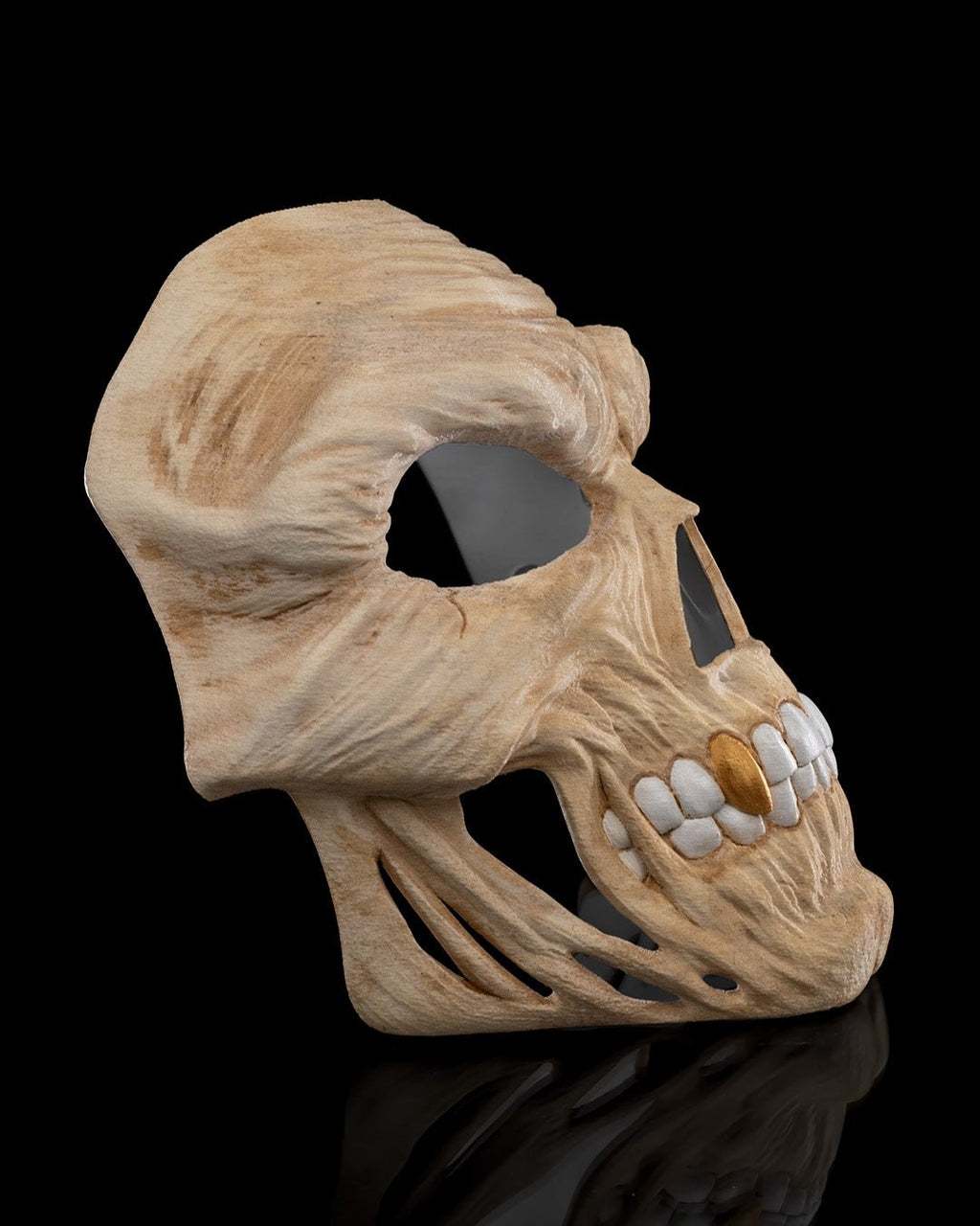 Totenkopf-Halloween-Maske in Creme mit goldenem Zahn-Akzent, Seitenprofil vor schwarzem Hintergrund
