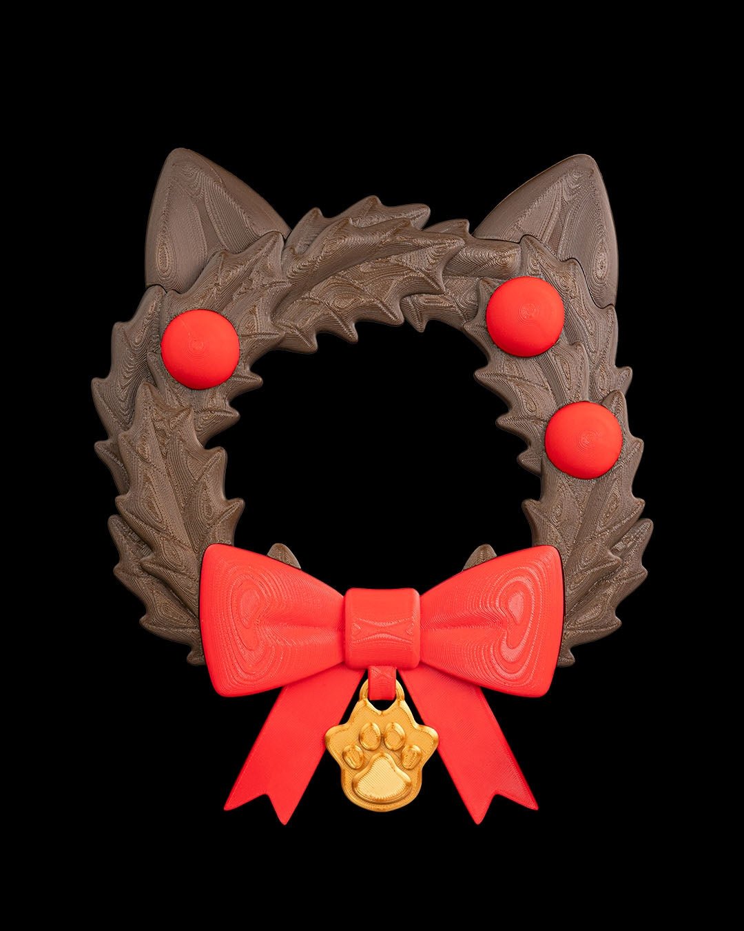 Weihnachtskranz in Katzenkopf-Form aus dunklem Tannengrün mit spitzen Katzenohren, drei roten Kugeln, roter Schleife und goldenem Pfotenanhänger, Frontalansicht vor schwarzem Hintergrund