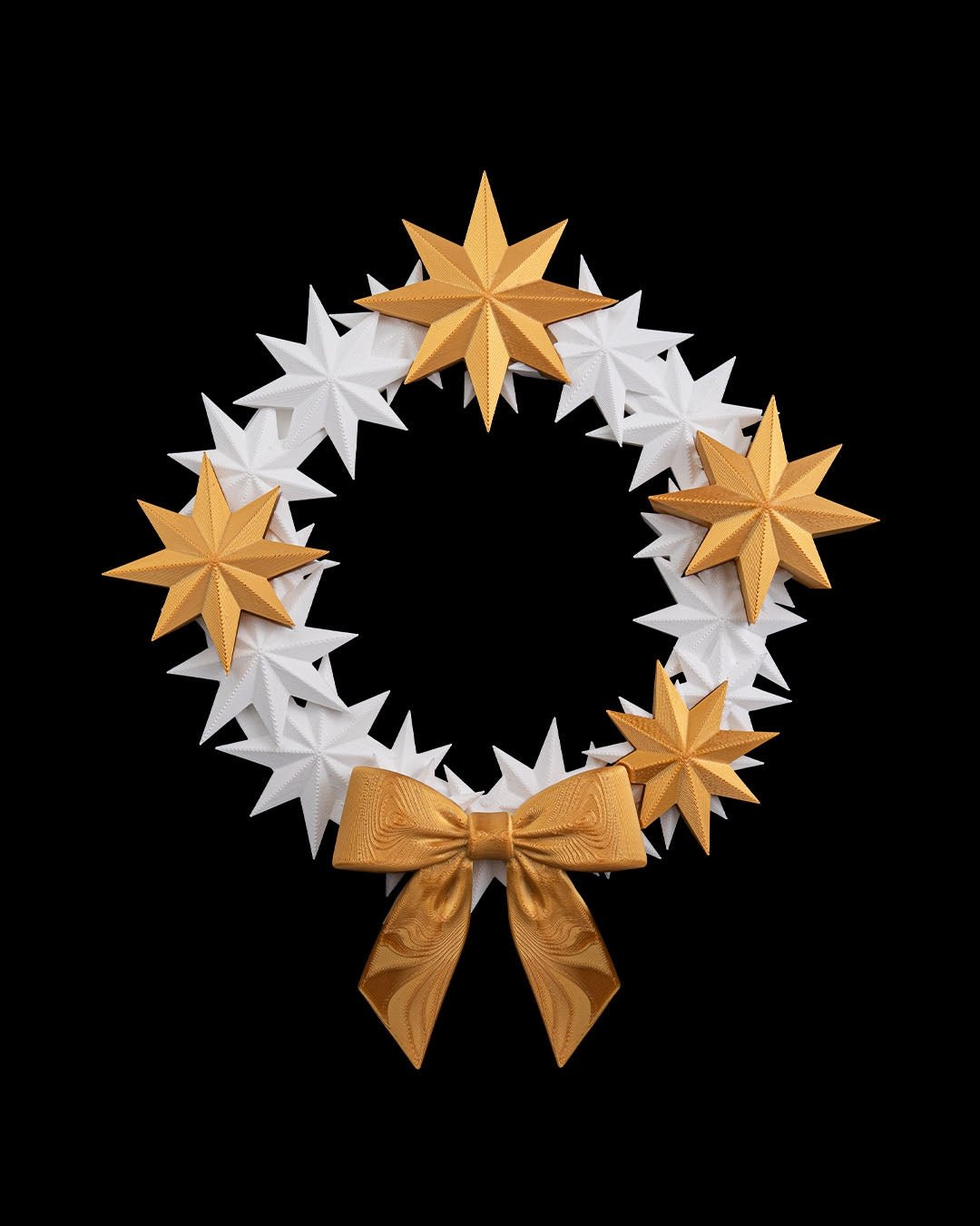 Sternenkranz aus weißen und goldenen 3D-gedruckten Sternen mit goldener Schleife, Frontalansicht vor schwarzem Hintergrund