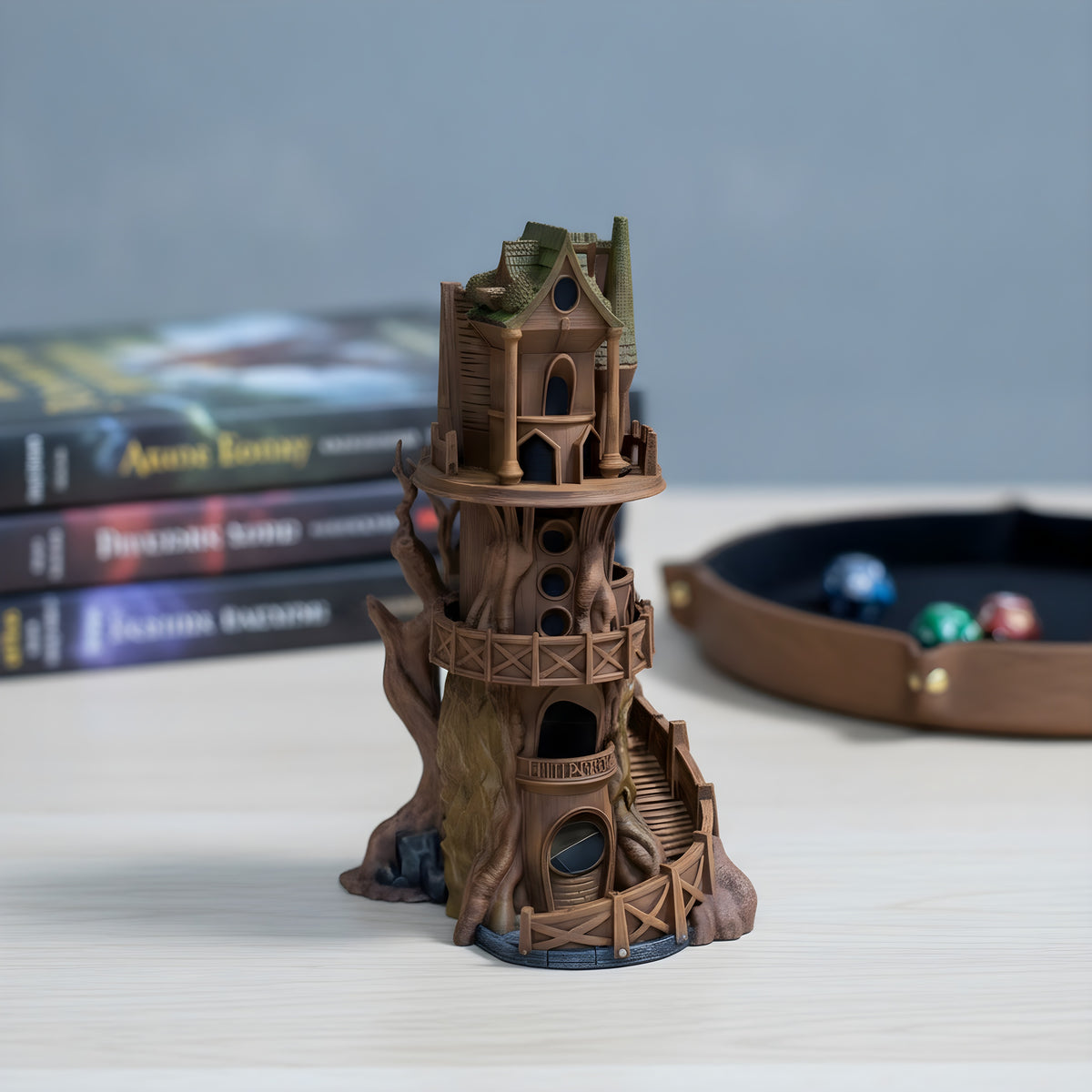 Wachturm Würfelturm bemalt, Frontalansicht auf hellem Eschenholz-Tisch mit RPG-Regelbüchern im Hintergrund
