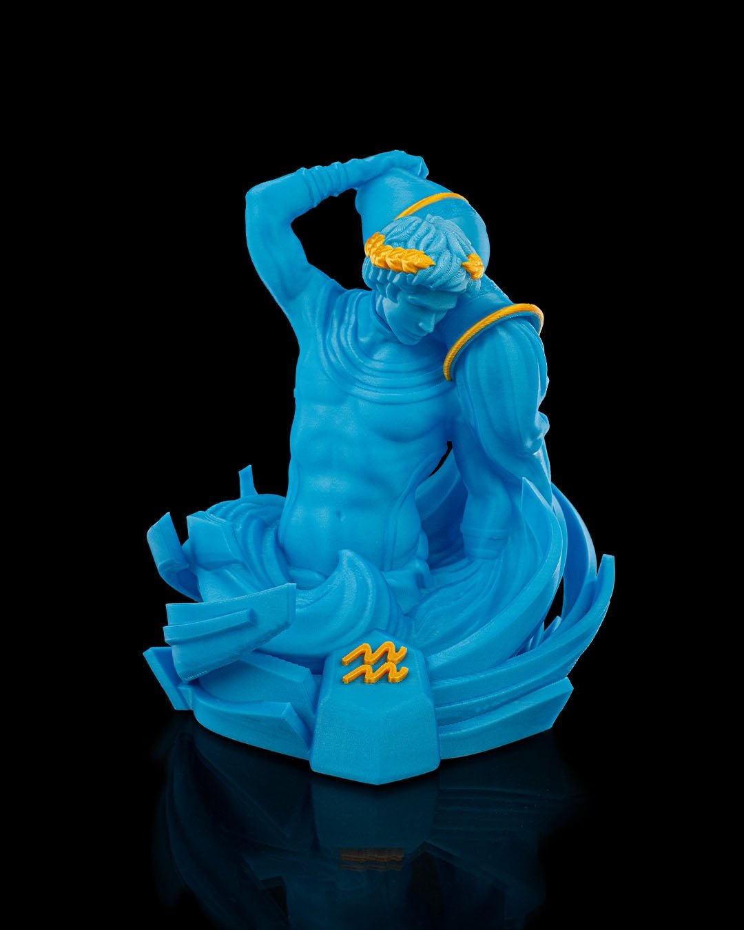 Wassermann-Figur in Blau mit goldenen Akzenten, Frontalansicht mit Sternzeichen-Symbol am Sockel, vor schwarzem Hintergrund