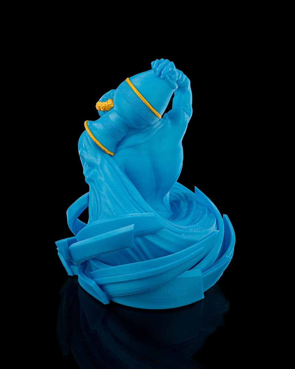 Wassermann-Figur in Blau aus schräger Perspektive mit Wasserdetails am Sockel, vor schwarzem Hintergrund