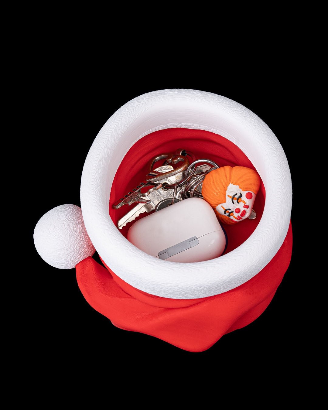 Weihnachtsmann Mütze Schale von oben, gefüllt mit Schlüsseln, Kopfhörer-Case und kleiner Figur als Schlüsselablage – Münch3D