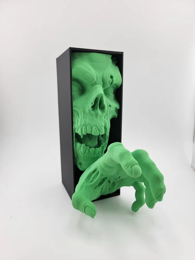 Zombie-Buchstütze in leuchtendem Grün aus schwarzer Box, Dreiviertelansicht auf hellem Hintergrund
